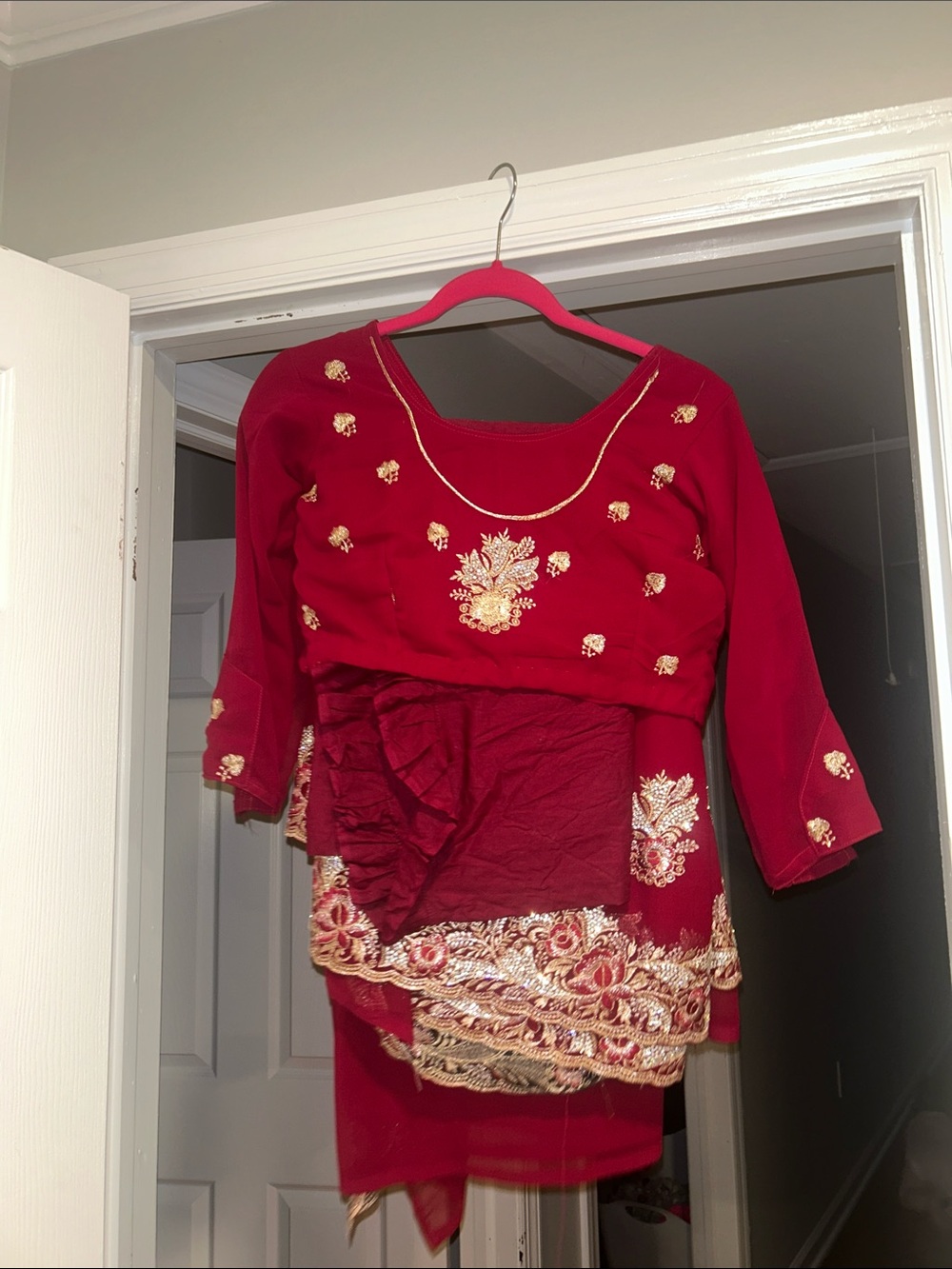 Crimson red Indian saree adorned with intricate gold zari and sequin embroidery